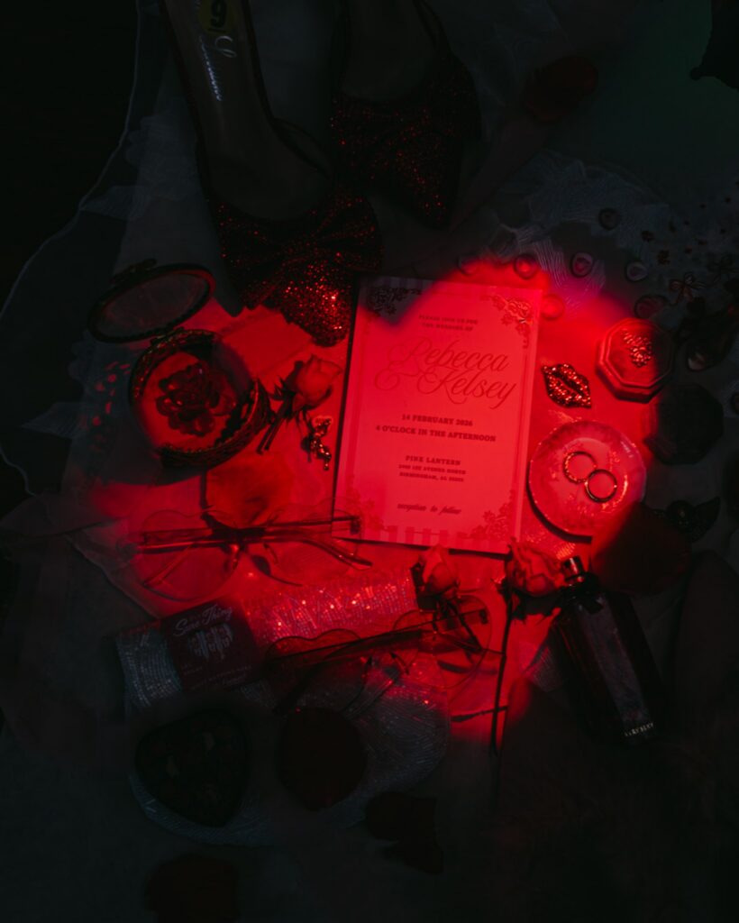 Alabama Elopement flat lay featuring Cupid stationery, cocktail menu, and romantic red and pink wedding details in Birmingham Alabama.