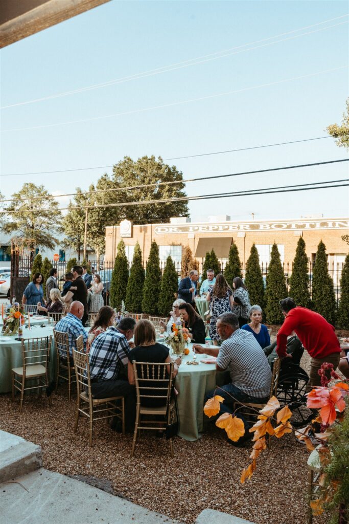 The Sage Birmingham venue courtyard is filled with guests dining at a colorful Alabama wedding 