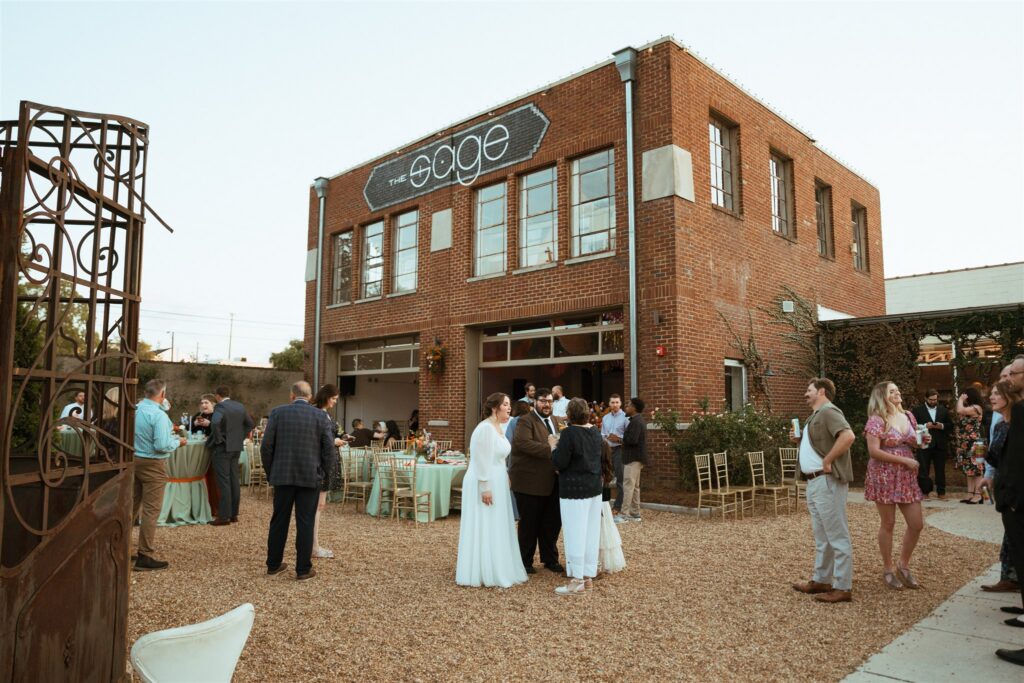 Newlyweds mingle with guests in the outdoor courtyard at their wedding reception held at The Sage in Birmingham AL