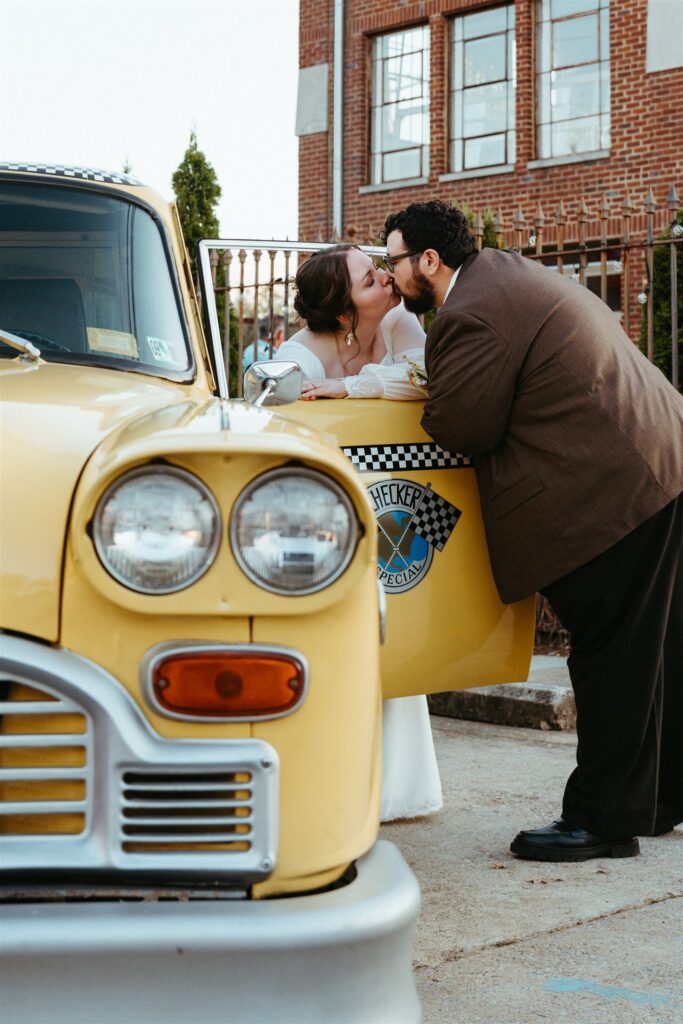 A newlywed couple share a kiss through the window of their getaway cab outside a Birmingham venue