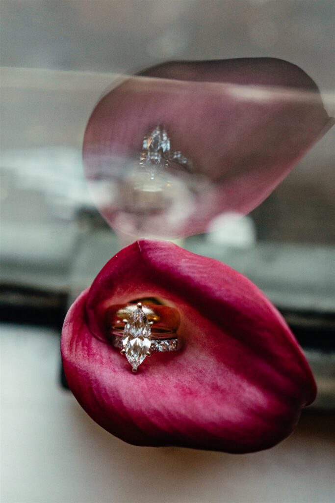 A marquis diamond ring sets inside a deep red calla lily taken at a reception held at The Florentine Birmingham