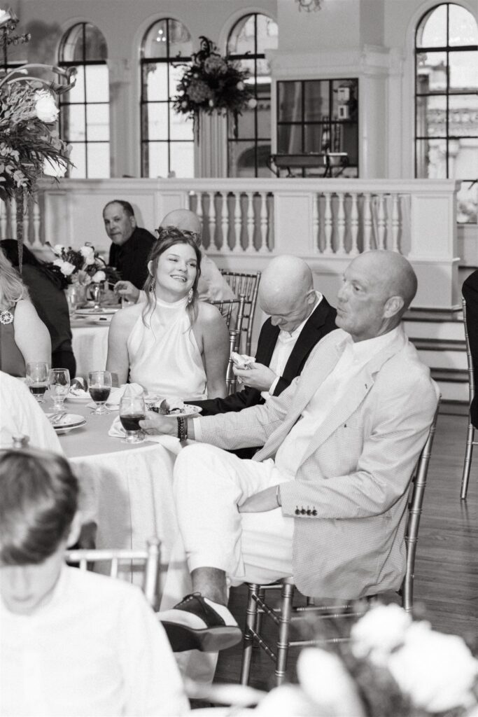 An image taken by a Birmingham wedding photographer shows a bride & groom laughing with guests at their reception held at The Florentine