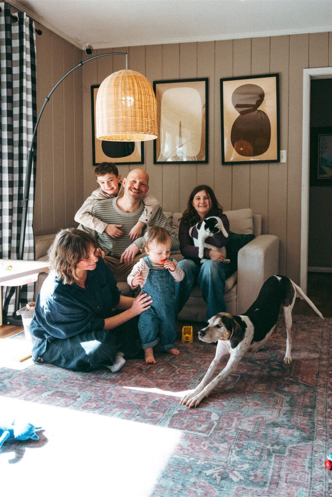 A family relaxes in their living room with their pets during an in-home session with an alabama family photographer