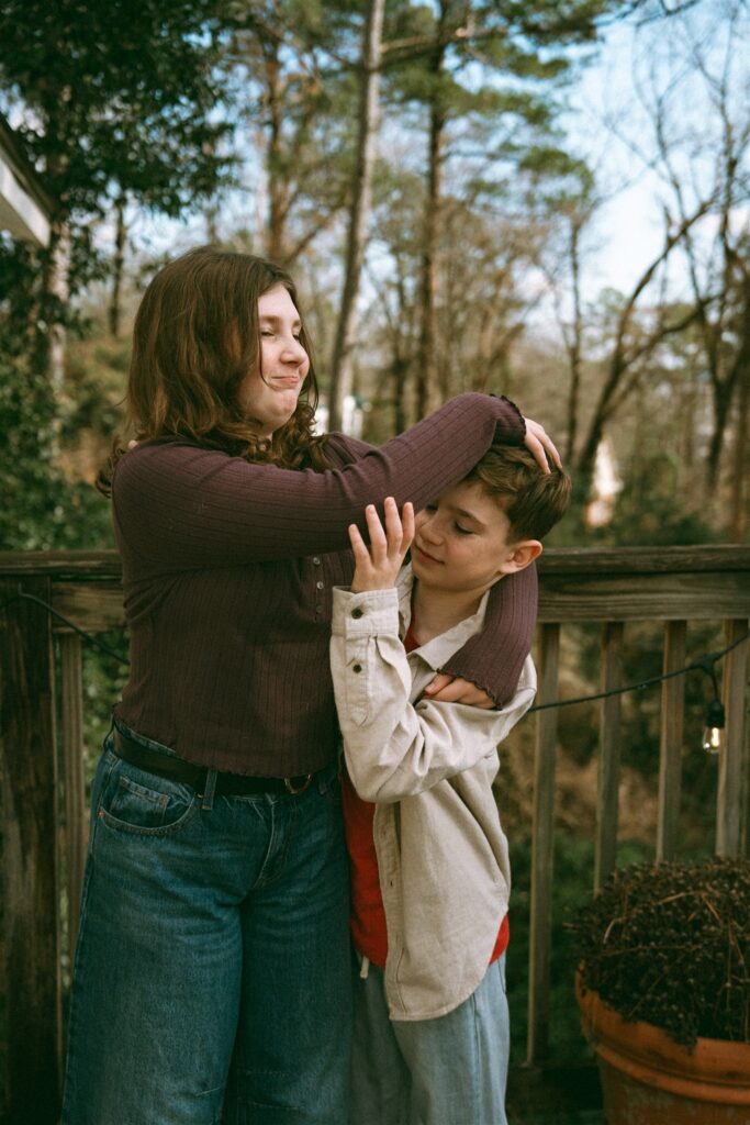 Siblings joke on their deck during family portraits birmingham alabama