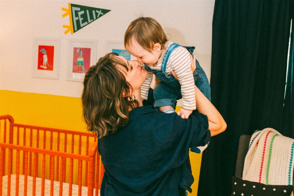 A mother lifts her toddler into the air during a photoshoot with an alabama family photographer