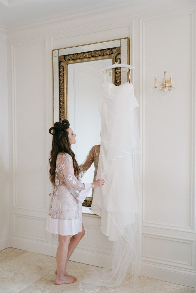 A bride admires her wedding dress in the Rock House bridal suite before her Stonehaven wedding 