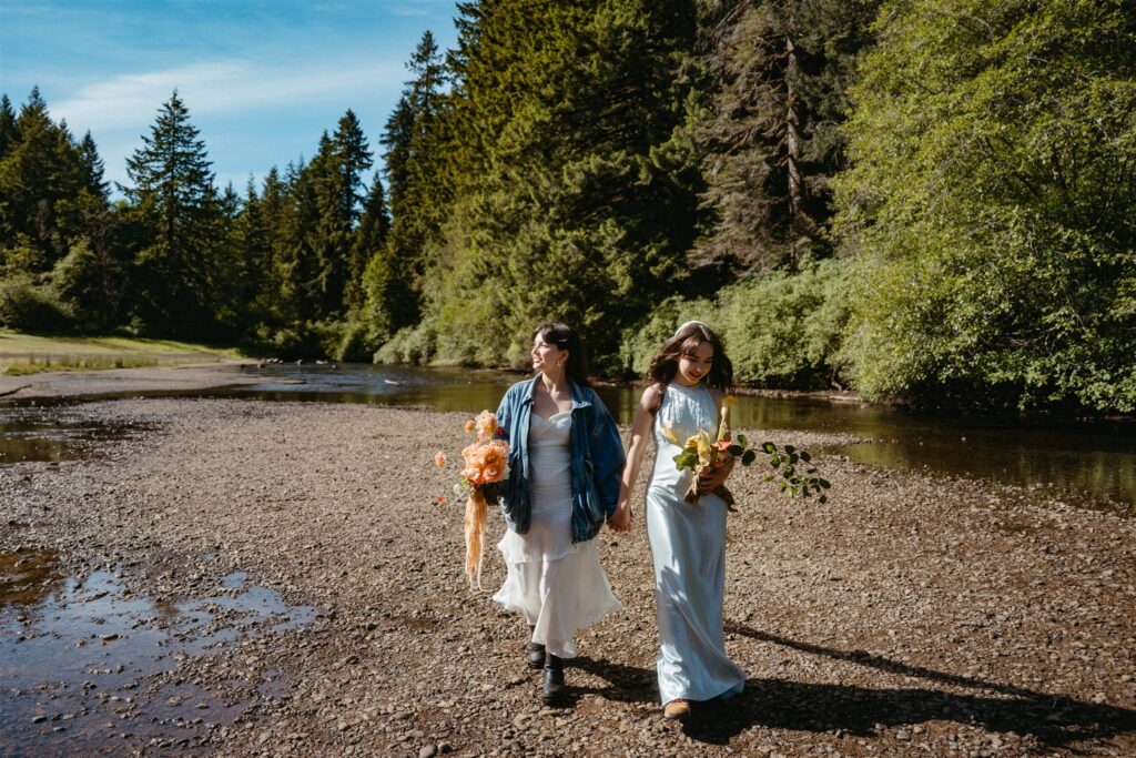 Oregon coast elopement brides walking along a waterfall trail in Silver Falls Oregon