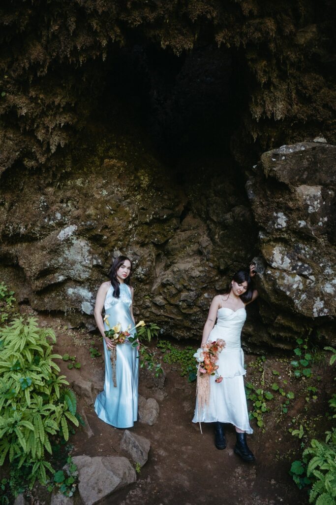 Brides are photographed walking while holding colorful bouquets at their elopement in Silver Falls State Park oregon