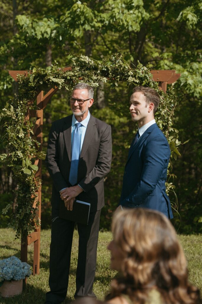 A groom and his officiant father look on from the altar at a Pigeon Forge elopement ceremony. 