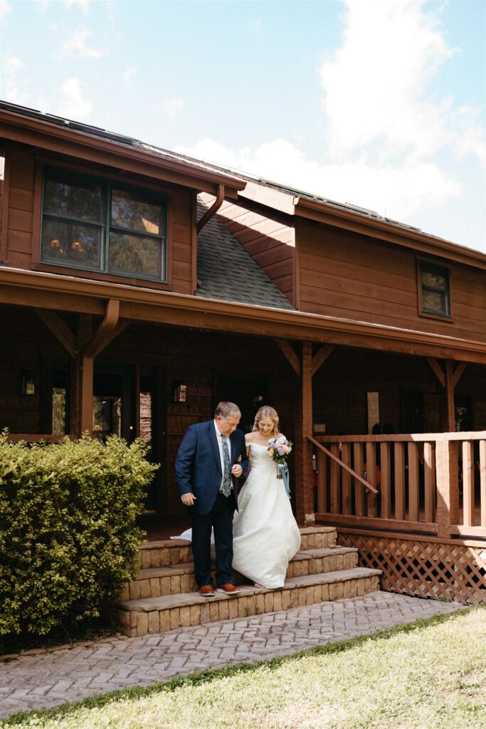 A bride's father escorts her down the aisle of her outdoor ceremony while eloping in Pigeon Forge Tennessee. 