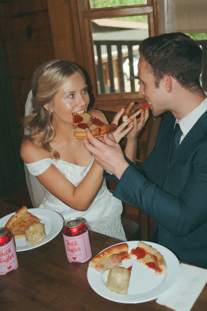Newlyweds feed each other slices of pizza following their Pigeon Forge elopement. 