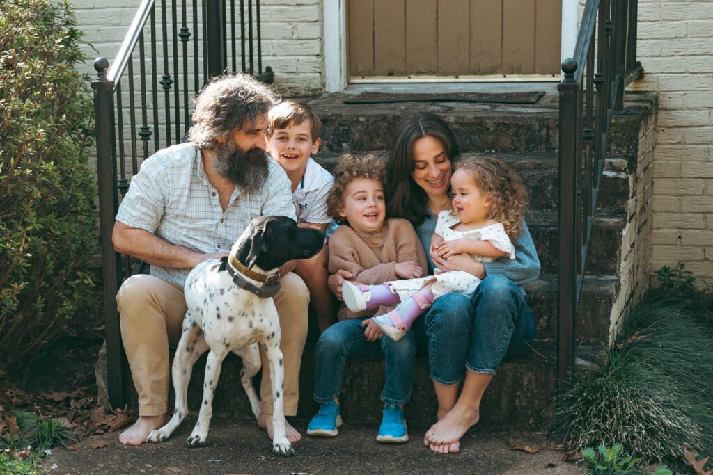 An Alabama family of five are seated on the front stoop of their house for family portraits Birmingham.