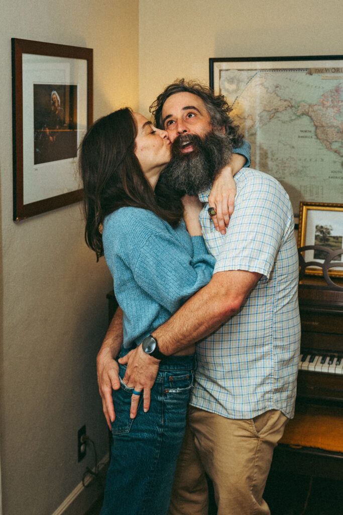 An Alabama couple embrace for a photo in their living room during an in home family photoshoot in Birmingham AL.
